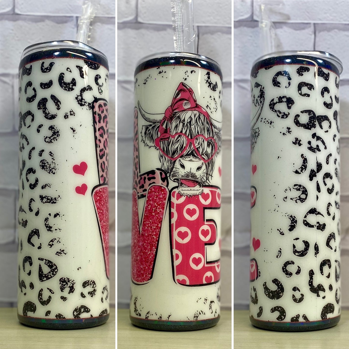 A white glittered stainless steel tumbler with black leopard print and a highland cow drawing and the word LOVE