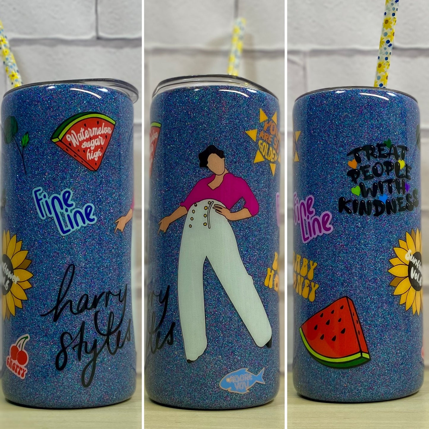 A 15oz stainless steel tumbler with a blue sparkled background and various designs including a cartoon of a person, a fish, and text phrases such as and 'treat people with kindness'.