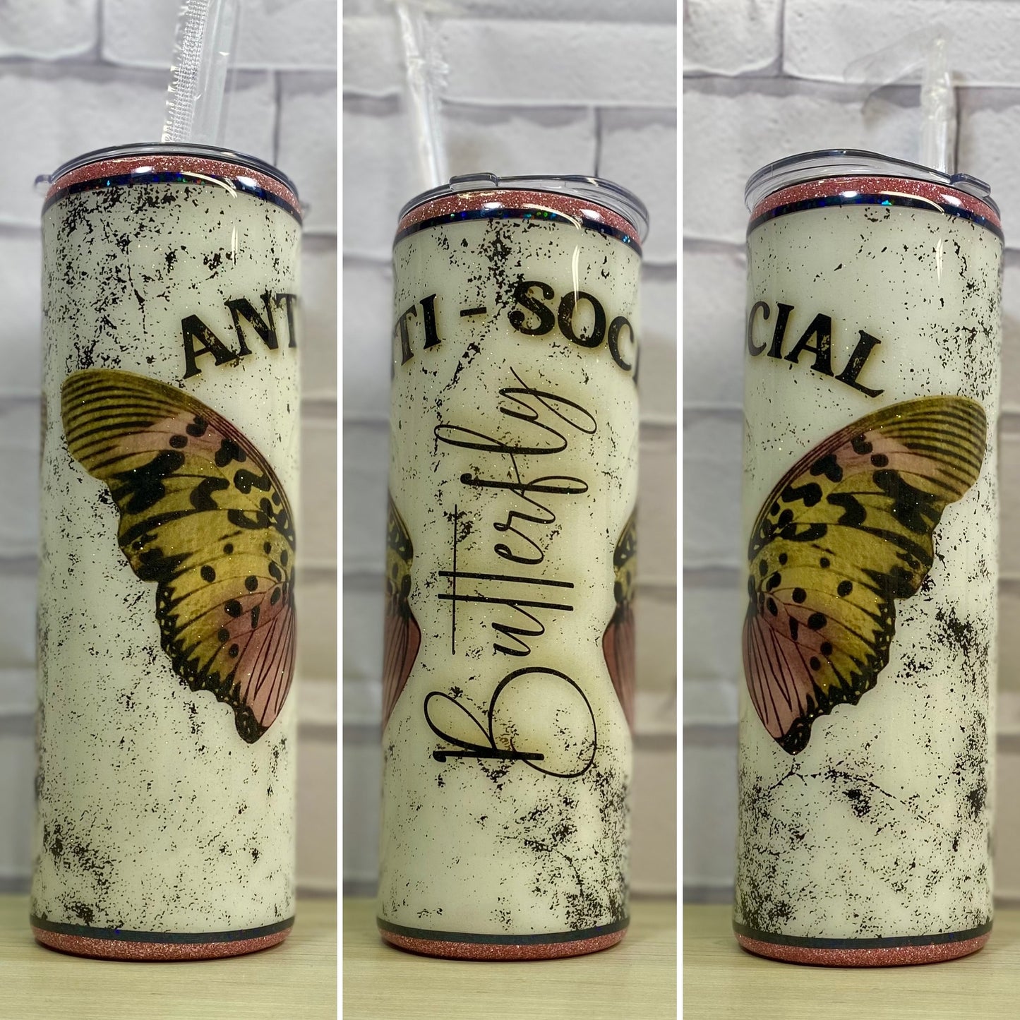 A white glittered tumbler with butterfly wings saying "anti-social" butterfly