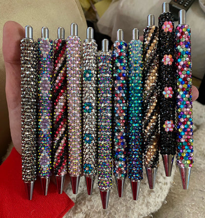 A assortment of rhinestoned pens in various colours and patterns