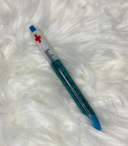 A custom order glitter pen with a blue body, white cap with a red cross.